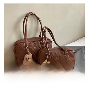 Detail of coffee brown quilted tote bags with plush dog charms and silver logo