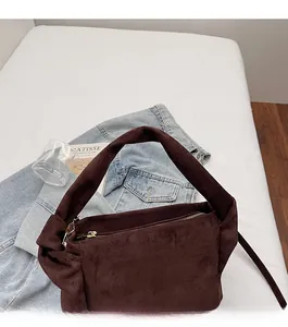 Top view of a dark brown suede shoulder bag with natural pleats and wide handles
