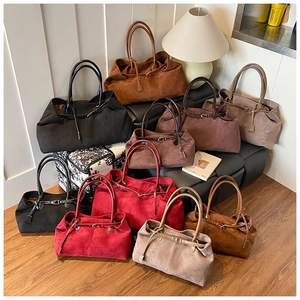 Macro display of large tote bags in multiple colors with matte suede finish and belt detail