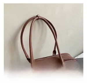 Detail shot of brown quilted shoulder bag with fine stitching and zip closure
