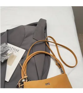 Close-up of mustard yellow vintage tote bag with silver ball charm and long shoulder strap