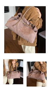 Detail showing the pleated faux suede surface and brown leather straps of the tote bag