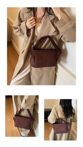 Detailed view of the dark brown suede bag with padded handle and adjustable strap