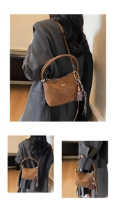 Detail view of vintage brown soft leather bucket bag with leopard bear and tassel charm