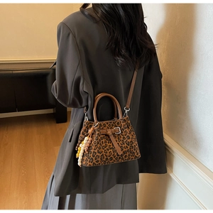 Detail of leopard print crossbody bucket bag with beaded tassel and round handles