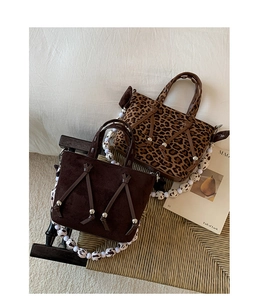 Close-up of vintage tote bags with leopard print and beaded straps on a wooden chair