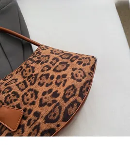 Close-up of vintage leopard print fabric and brown leather trim on the crossbody bag