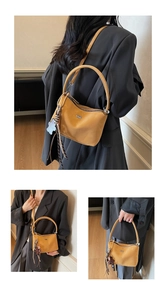 Detail of vintage tan leather bucket bag with sequin star charm and adjustable strap