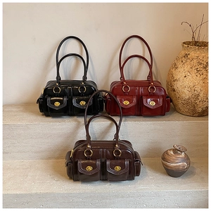 Detail of vintage oil wax leather Boston bags in black, burgundy, and brown with gold hardware