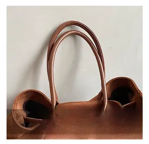 Detail of soft brown suede tote bag handle and spacious opening with dark lining