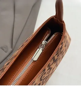 Detail of premium leopard print bag featuring a smooth metal zipper and refined lining