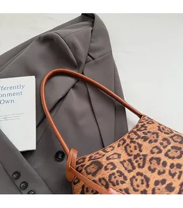 Detail of French vintage leopard print shoulder bag with brown cylindrical strap