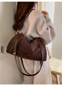 Mannequin portant un grand sac porté épaule en daim marron foncé pour un look stylé