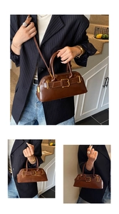 Brown leather crossbody bag detail showing double handle and belt buckle strap design