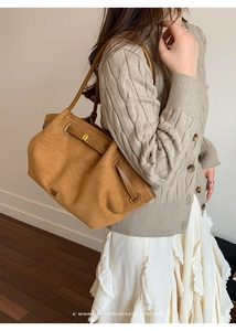 Detail of retro suede tote bag showing contrast leather straps and gold metal hardware