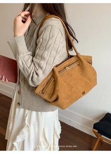 Detail of caramel suede tote bag with white stitching and drawstring closure