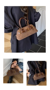 Detail view of brown suede shell bag with vintage gold buckle and smooth leather handles