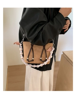 Detail of leopard print velvet bucket bag with beaded handle worn by a model