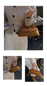 Detail of a brown shell-shaped tote bag with frosted leather and metal buckle detail