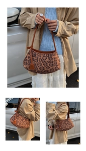 Detailed view of leopard print faux suede texture and brown leather strap on hobo bag
