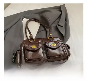 Detailed view of dark brown faux leather Boston bag with golden twist locks and pockets