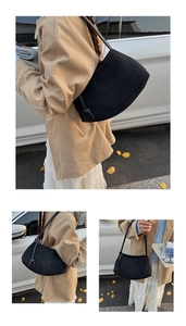Detailed close-up of a minimalist black suede half-moon shoulder bag for autumn fashion