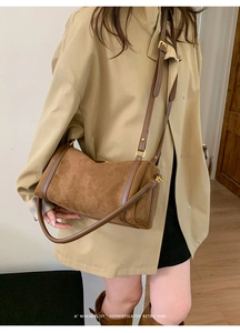 Détail du sac Boston en daim marron rétro avec finitions en cuir et boucles dorées