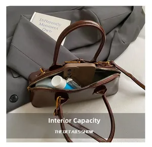 Macro shot showing internal capacity of the dark brown shell bag with daily essentials
