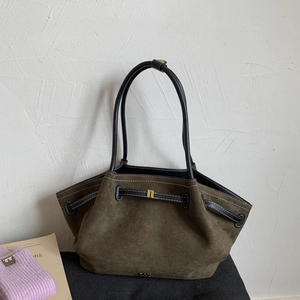 Detail of dark olive suede tote bag with black leather straps and gold metal buckle