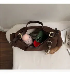 Interno spazioso della borsa tote in pelle scamosciata marrone con zip e scomparti