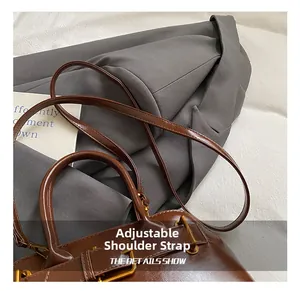 Detailed macro view of the brown patent leather texture and adjustable golden metal buckle