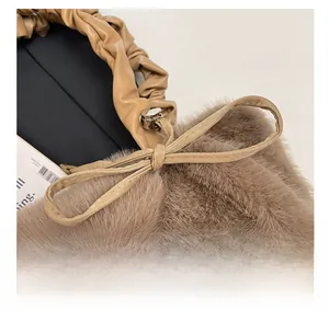 Detail of plush brown faux fur handbag with khaki pleated leather handle and bow accent