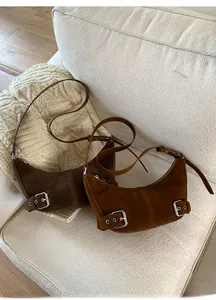 Vue détaillée des sacs croissant en daim avec boucles métalliques aux tons automnaux