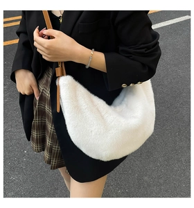 Détail du sac croissant en peluche blanche avec bandoulière en cuir marron portée