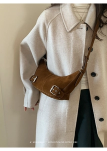 Détail du sac hobo en daim caramel avec boucles métalliques et texture rétro minimaliste