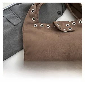 Détail macro du tissu en suédine marron avec rivets décoratifs à œillets métalliques
