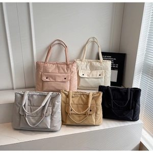Detailansicht der wattierten Schultertaschen in fünf Farben auf weißem Podest