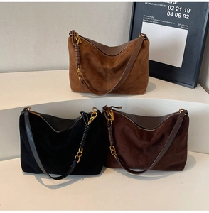 Detailed view of suede tote bags in black and brown with leather straps and gold hardware