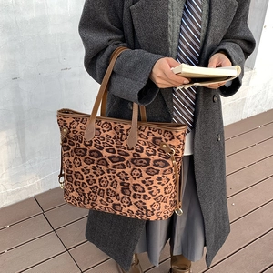Detailed side view of leopard print tote bag with adjustable straps on model