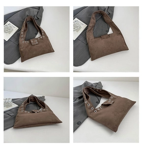 Détails macro d'un sac à main en daim marron foncé avec œillets métalliques et fini mat