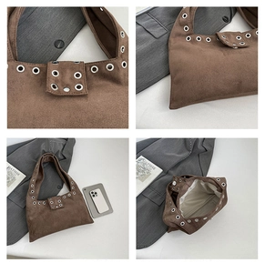 Vue détaillée du sac cabas en daim marron avec œillets métalliques et fermoir aimanté