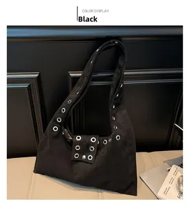 Détail du sac hobo en daim noir avec œillets métalliques argentés et fermoir aimanté