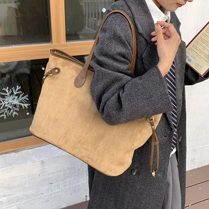 Detail of a large leopard print tote bag in brown suede with leather trim on model