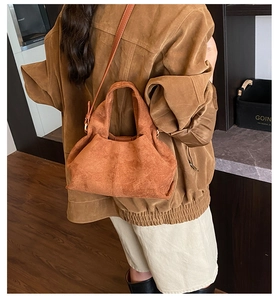 Sac nuage en daim caramel porté par un mannequin dans un décor vintage chic