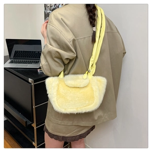 Detail of plush yellow shoulder bag featuring soft faux fur texture and leather strap