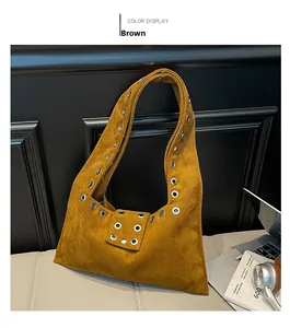 Détail du sac vintage en cuir marron avec des œillets métalliques argentés décoratifs
