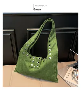 Détail du sac à bandoulière en daim vert avec œillets métalliques argentés vintage