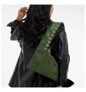 Detail of dark green suede shoulder bag featuring silver metal eyelet grommet straps