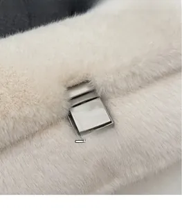 Macro shot of silver metal square buckle on premium cream faux fur handbag detail