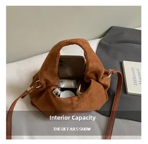 Macro shot of brown suede bucket bag interior showing capacity for phone and cosmetics